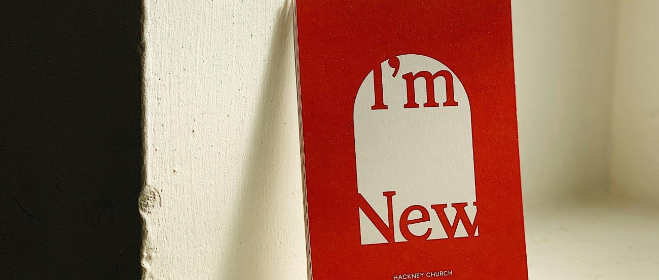 Ein rotes Buch lehnt an einem Fenstersims an der Wand. Auf dem Cover steht 'I'm new'