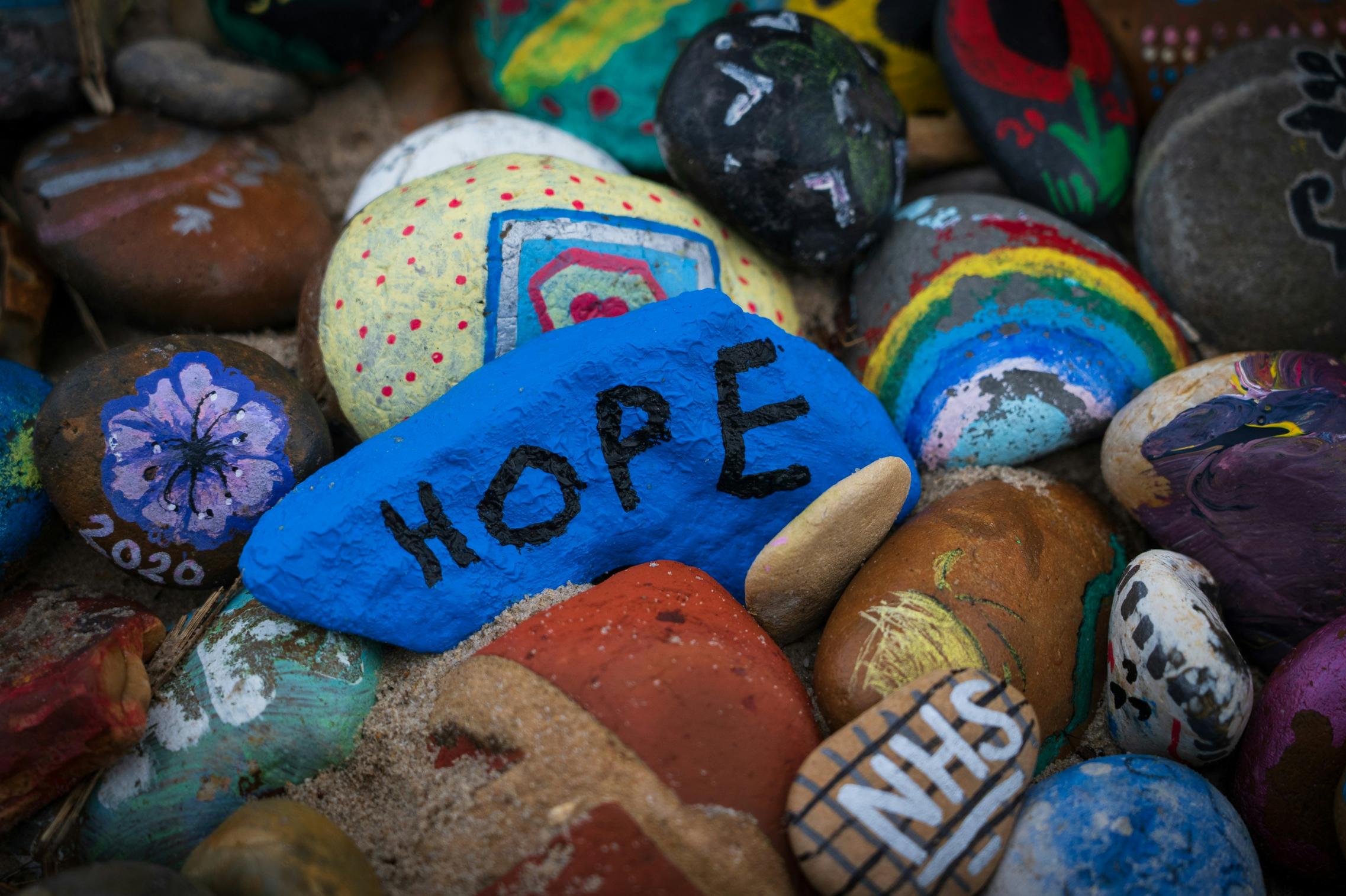 Steine sind bunt bemalt, auf einem steht das Wort Hope