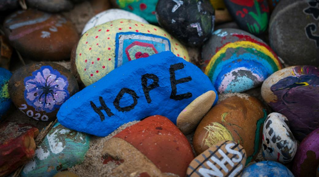 Steine sind bunt bemalt, auf einem steht das Wort Hope