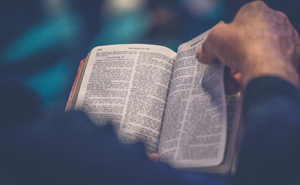Ein Mensch hält eine Bibel in der Hand und liest darin
