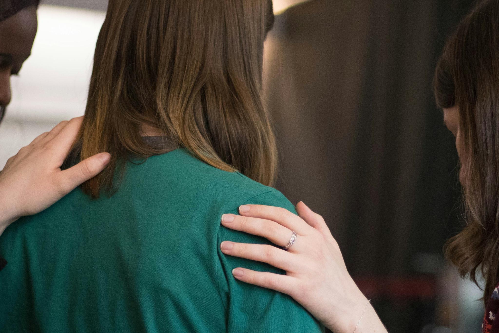 Mehrere Frauen stehen nebeneinander im Gebet und stützen sich