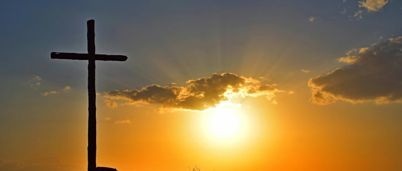 Kreuz vor Sonnenuntergang (c) Cdoncel auf Unsplash Blick in einen Sonnenuntergang. Auf einem kleinen Hügel steht in Kreuz, es ist nur als Silhouette zu sehen