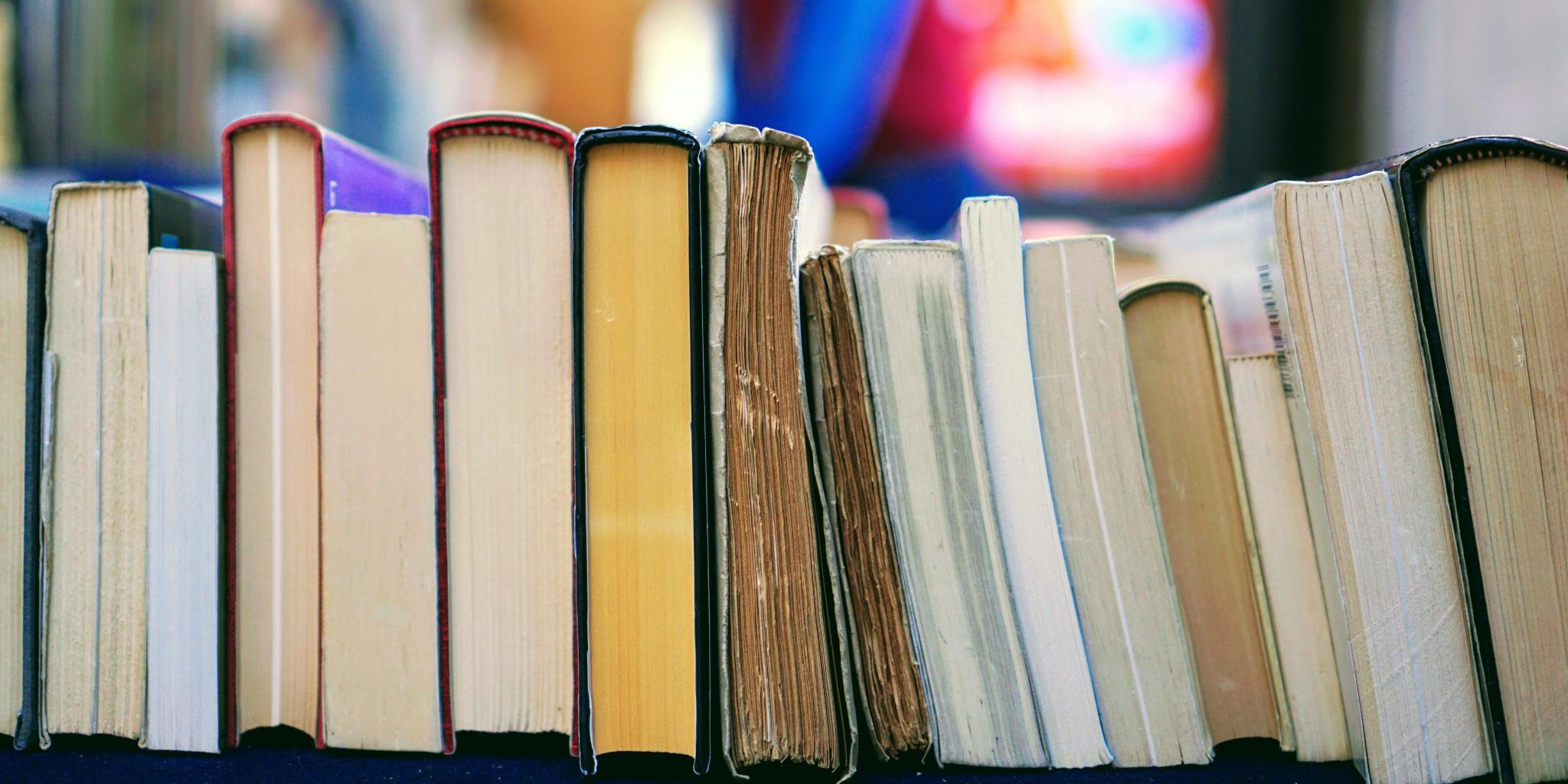 Mehrere Bücher sind in einer Reihe nebeneinander angeordenet.