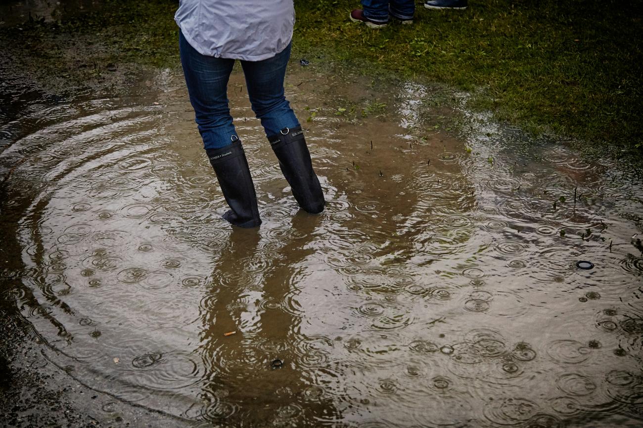 Symbolbild (c) Vidar Nordli-Mathisen auf Unsplash Eine Person steht in einer sehr großen Pfütze