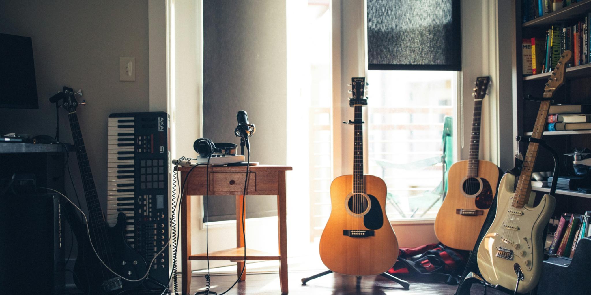 In einem Raum mit einem großen Fenster stehen Gitarren und ein Keyboard