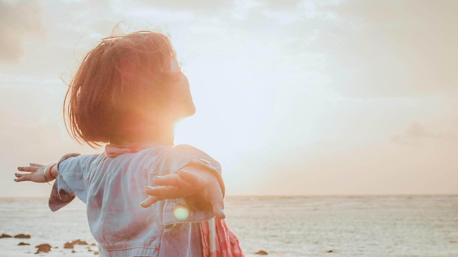 Junge Frau lässt sich die Sonne in das Gesicht scheinen