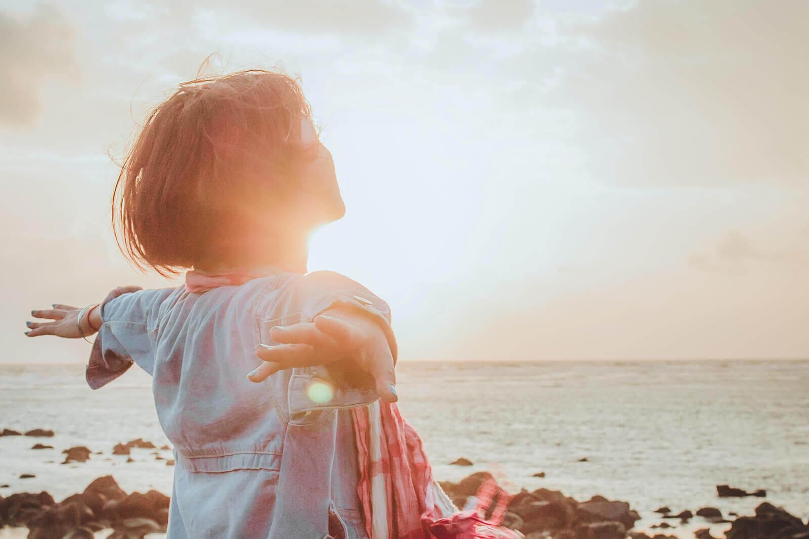Junge Frau lässt sich die Sonne in das Gesicht scheinen