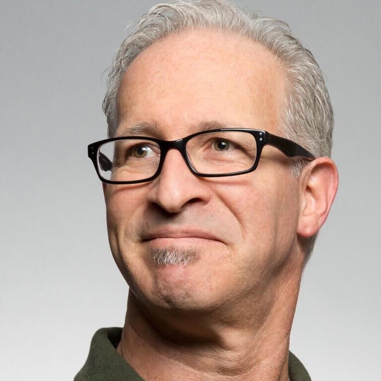 Portrait eines Mannes mit Brille vor hellem Hintergrund